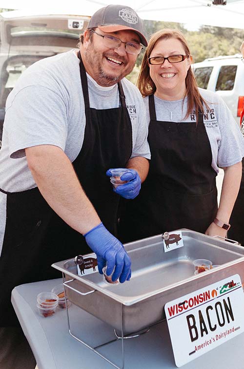Jake and Stacey wearing aprons at table at farmers market